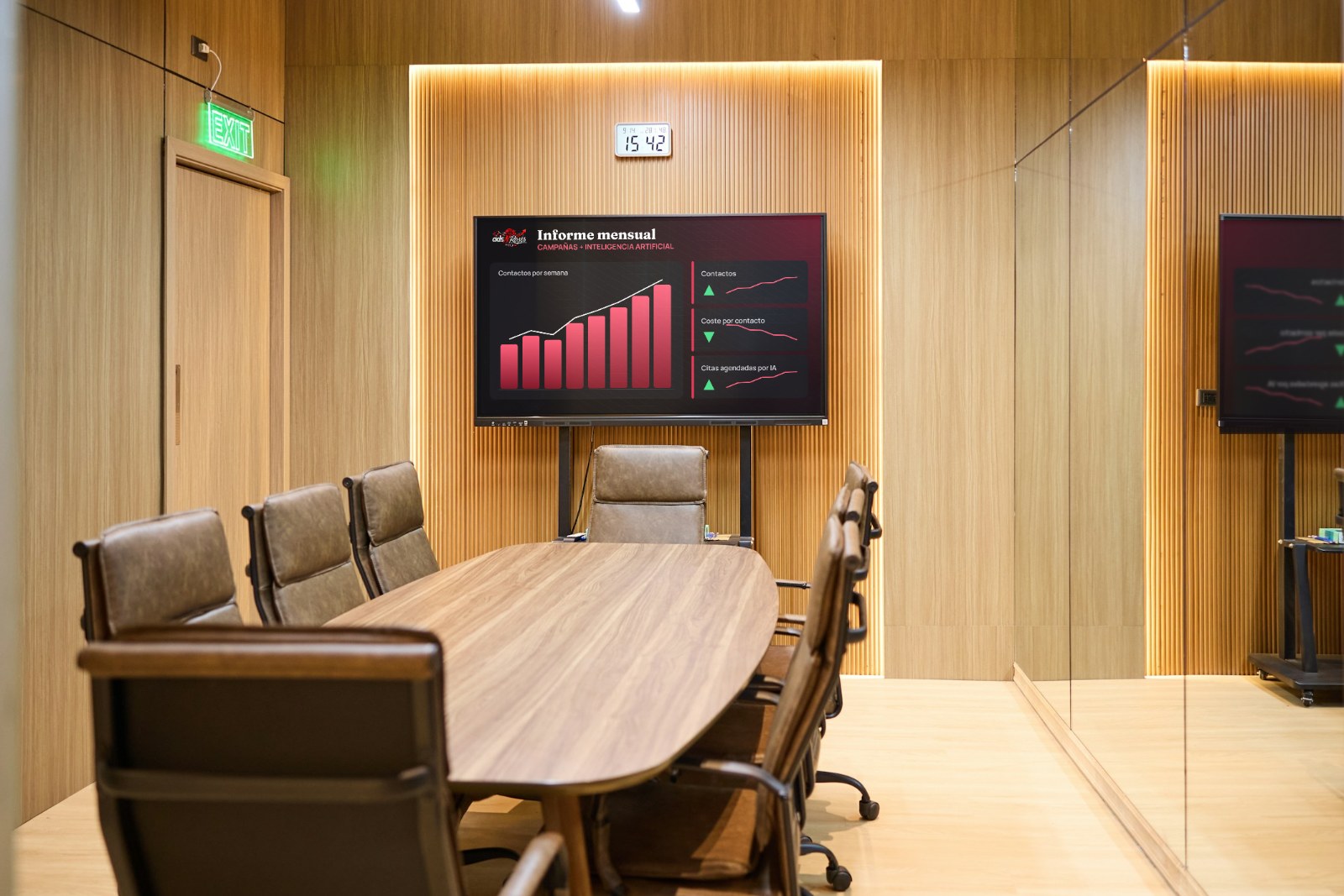 Sala de juntas con un informe de campañas e inteligencia artificial en pantalla